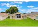 Home's backyard with a screened lanai overlooking a beautifully landscaped lawn at 464 Lake Suzanne Dr, Lake Wales, FL 33859