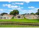 Home featuring a screened lanai and a spacious backyard with lush green grass at 464 Lake Suzanne Dr, Lake Wales, FL 33859