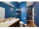 This bathroom features blue walls, wood floor, shelves, and granite countertop at 4662 Osprey Way, Winter Haven, FL 33881