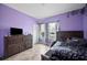 Cozy bedroom featuring light purple walls and a neutral-toned tiled floor. A window provides natural light at 4662 Osprey Way, Winter Haven, FL 33881