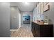 The hallway features dark wood floors, gray walls, and a decorative ornate dresser at 4662 Osprey Way, Winter Haven, FL 33881