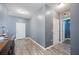 This hallway features dark wood floors, gray walls, and leads to the laundry room at 4662 Osprey Way, Winter Haven, FL 33881