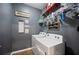 This laundry room features white washer and dryer, gray walls and overhead storage at 4662 Osprey Way, Winter Haven, FL 33881
