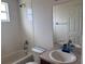Functional bathroom with tub-shower combo, tile surround, and vanity sink with mirror at 4747 Mandolin Loop, Winter Haven, FL 33884