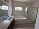Bathroom with a vanity and sink, and a shower/tub combo with glass doors, and an arched window at 4747 Mandolin Loop, Winter Haven, FL 33884