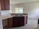 Cozy kitchen area with wooden cabinets, laminate countertops, and view into adjacent living area at 4747 Mandolin Loop, Winter Haven, FL 33884