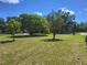 The front yard boasts lush greenery and mature trees, offering curb appeal at 514 7Th S St, Dundee, FL 33838