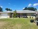 Charming single-story home with well-manicured lawn, front porch with black flower pots, and a brick exterior at 514 7Th S St, Dundee, FL 33838
