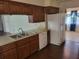Functional kitchen with wood cabinetry, stainless steel sink, and white refrigerator, providing convenience at 514 7Th S St, Dundee, FL 33838