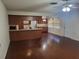 Open-concept living room flows to the kitchen, featuring wood flooring, ceiling fan, and ample lighting at 514 7Th S St, Dundee, FL 33838