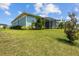Backyard of a home, with a view of the screened-in patio and lush green lawn at 545 Pond Cypress Ct, Auburndale, FL 33823