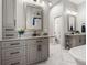Bathroom featuring gray cabinets, granite counters, and a large framed mirror at 545 Pond Cypress Ct, Auburndale, FL 33823