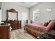 Bright bedroom featuring a large dresser, comfortable chair, and a well-lit window at 545 Pond Cypress Ct, Auburndale, FL 33823