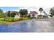 Well-maintained community entrance with lush landscaping, an entry gate, and gate house at 545 Pond Cypress Ct, Auburndale, FL 33823