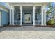 Inviting front entrance features stately columns, a covered porch, and meticulously landscaped surroundings at 545 Pond Cypress Ct, Auburndale, FL 33823
