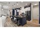 Open-concept kitchen with a large island, black countertops, white cabinets, and stainless steel appliances at 545 Pond Cypress Ct, Auburndale, FL 33823