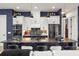 Modern kitchen featuring a large island with a black marble countertop, white cabinets, and pendant lighting at 545 Pond Cypress Ct, Auburndale, FL 33823