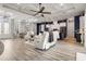 Stylish open-concept living space with modern decor, hardwood floors, and a decorative ceiling at 545 Pond Cypress Ct, Auburndale, FL 33823
