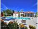 Community pool with lounge chairs, colorful landscaping, and a clubhouse at 545 Pond Cypress Ct, Auburndale, FL 33823