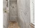 A marble-tiled walk-in shower with a pebble floor and a rainfall shower head at 545 Pond Cypress Ct, Auburndale, FL 33823