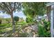 Lush backyard with mature trees, well-maintained landscaping, and inviting patio at 6027 Grand Oaks Se Dr, Winter Haven, FL 33884