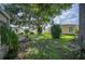 Spacious backyard with mature trees, grass, and landscaping between the houses at 6027 Grand Oaks Se Dr, Winter Haven, FL 33884