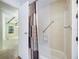 Bathroom features a safety bar in the shower and hallway view at 6027 Grand Oaks Se Dr, Winter Haven, FL 33884