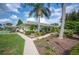 Well-maintained house featuring manicured landscaping, a sidewalk, and tall palm trees at 6027 Grand Oaks Se Dr, Winter Haven, FL 33884