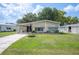 Inviting single-story home featuring a well-maintained lawn, covered carport and manicured landscaping at 6027 Grand Oaks Se Dr, Winter Haven, FL 33884