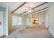 Bright living room with vaulted ceilings, exposed wood beams, carpet flooring and lots of natural light at 6027 Grand Oaks Se Dr, Winter Haven, FL 33884