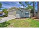 Exterior of home with a two-car garage and well maintained lawn at 658 Lake Dexter Cir, Winter Haven, FL 33884