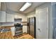 Well-lit kitchen featuring stainless steel appliances, butcher block countertops, and white cabinets at 658 Lake Dexter Cir, Winter Haven, FL 33884