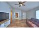 Bright and airy living room showcasing hardwood floors, ceiling fan, and a view into an adjacent room at 658 Lake Dexter Cir, Winter Haven, FL 33884