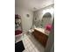 Bathroom featuring a wooden vanity, oval mirror, and decor at 7906 Waterview Way # 7906, Winter Haven, FL 33884