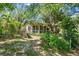 Backyard with mature trees and lush landscaping with screen porch in view at 836 S Lake Starr Blvd, Lake Wales, FL 33898