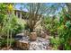 Outdoor stone seating area with tropical trees and plants behind the house at 836 S Lake Starr Blvd, Lake Wales, FL 33898