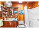 Compact bathroom featuring wood paneling, vanity with ample storage, and shower-tub combination at 836 S Lake Starr Blvd, Lake Wales, FL 33898