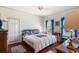 Bright bedroom with a full bed, wood floors, blue curtains, and a vintage vanity at 836 S Lake Starr Blvd, Lake Wales, FL 33898