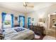 Bedroom with blue curtains, a dresser, and a glimpse into a hallway, showcasing a cozy layout at 836 S Lake Starr Blvd, Lake Wales, FL 33898