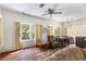 Cozy living room with hardwood floors, bright windows, and ceiling fan at 836 S Lake Starr Blvd, Lake Wales, FL 33898