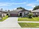 Well-kept home with a two-car garage, attractive landscaping, and a welcoming front entrance at 8720 Micmac Ct, Polk City, FL 33868