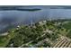 Aerial view of home on lakefront property with mature trees, a beach and private dock at 914 Mangham Rd, Babson Park, FL 33827