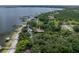 Aerial view of lakefront home nestled among trees, featuring private beach and dock at 914 Mangham Rd, Babson Park, FL 33827