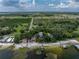 Aerial view of lakefront home featuring private beach, dock, and mature trees at 914 Mangham Rd, Babson Park, FL 33827