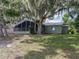 Expansive backyard with a screened-in porch and view of the lawn and mature trees draped with Spanish moss at 914 Mangham Rd, Babson Park, FL 33827
