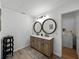 This updated bathroom features double sinks, decorative mirrors, a wooden vanity, and access to the laundry area at 914 Mangham Rd, Babson Park, FL 33827