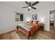 Cozy bedroom with a queen bed, wood floors, a ceiling fan, and a view to the outside at 914 Mangham Rd, Babson Park, FL 33827