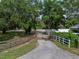 Gravel driveway leading to a spacious property with mature trees and fencing at 914 Mangham Rd, Babson Park, FL 33827