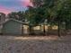 Charming home featuring a wooden deck and beautifully lit exterior, creating a cozy evening ambiance at 914 Mangham Rd, Babson Park, FL 33827