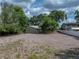 Exterior view of the home showcasing its simple architecture, metal roof, and spacious rock covered yard at 914 Mangham Rd, Babson Park, FL 33827